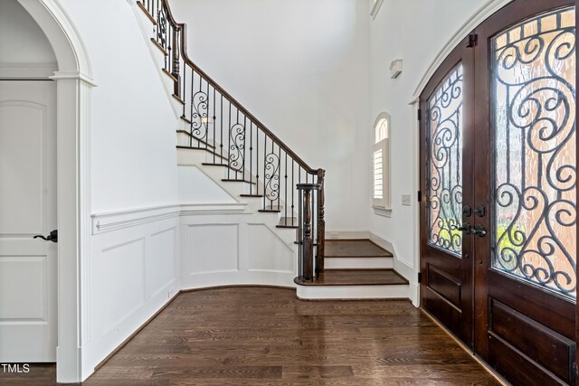 3908 Chaumont Dr, Apex, NC 27539 - entrance foyer with french doors, arched walkways, stairway, a decorative wall, and dark wood-type flooring