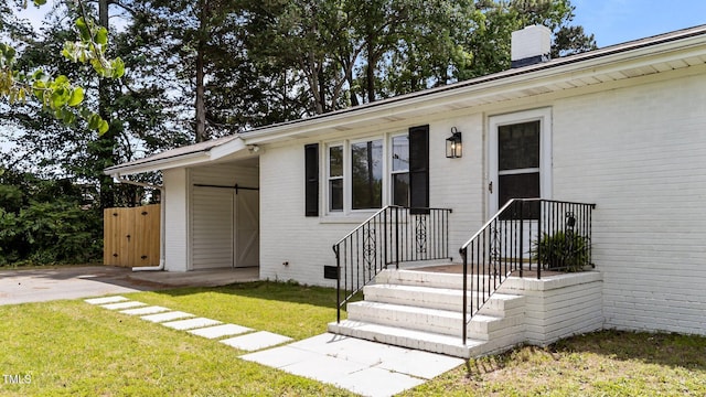 314 Wrenn St, Apex, NC 27502 - property entrance featuring brick siding, a lawn, and a chimney