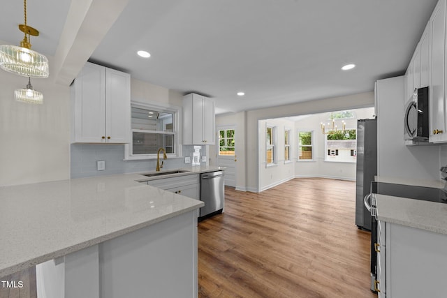 314 Wrenn St, Apex, NC 27502 - kitchen featuring stainless steel appliances, a sink, decorative backsplash, white cabinetry, and light stone counters