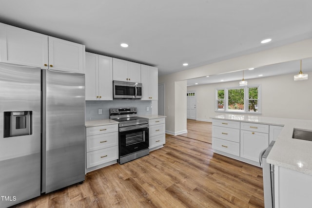 314 Wrenn St, Apex, NC 27502 - kitchen with appliances with stainless steel finishes, recessed lighting, light wood finished floors, white cabinets, and decorative backsplash