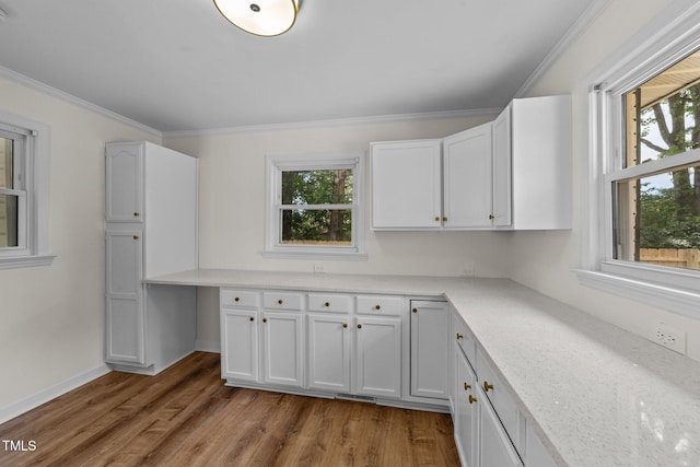 314 Wrenn St, Apex, NC 27502 - kitchen with plenty of natural light, wood finished floors, white cabinetry, ornamental molding, and baseboards