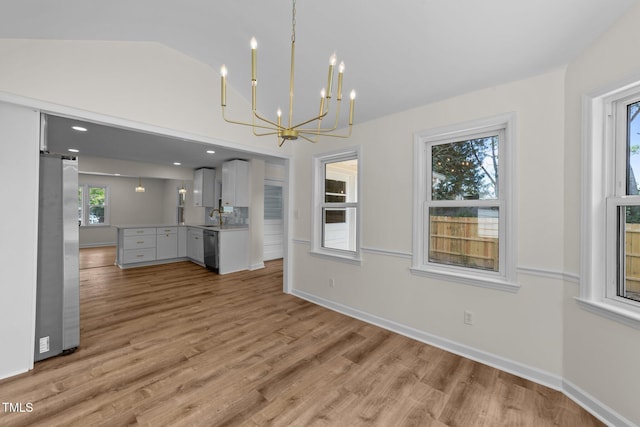 314 Wrenn St, Apex, NC 27502 - unfurnished living room featuring a sink, a chandelier, light wood-style flooring, and baseboards