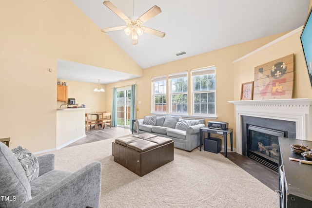 5312 Suntan Lake Dr, Raleigh, NC 27610 - living room with a fireplace with flush hearth, ceiling fan, high vaulted ceiling, a chandelier, and carpet