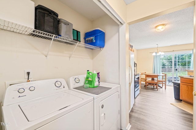 5312 Suntan Lake Dr, Raleigh, NC 27610 - laundry area featuring washing machine and dryer, light wood-type flooring, and a textured ceiling