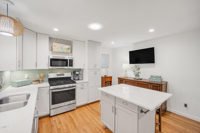 4021 Converse Dr, Raleigh, NC 27609 - kitchen featuring stainless steel appliances, decorative backsplash, light wood finished floors, white cabinets, and recessed lighting