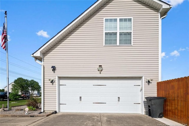 garage featuring fence and driveway