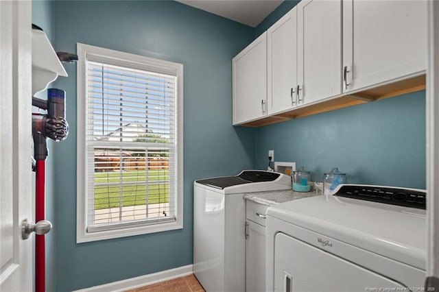clothes washing area featuring cabinet space, washer and clothes dryer, and baseboards