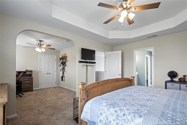 bedroom featuring carpet, a tray ceiling, baseboards, ceiling fan, and a desk