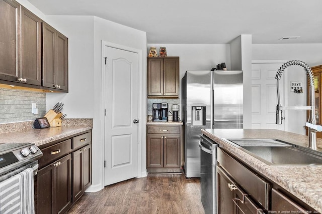34 Merlin Ct, Godwin, NC 28344 - kitchen featuring a sink, appliances with stainless steel finishes, dark brown cabinetry, dark wood-type flooring, and decorative backsplash