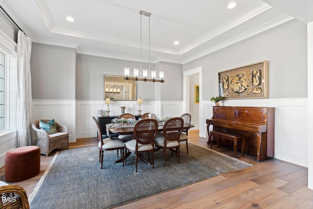 7212 Summer Tanager Trl, Raleigh, NC 27614 - dining area featuring a raised ceiling, wood-type flooring, a wainscoted wall, ornamental molding, and a decorative wall