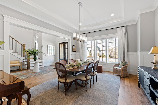 7212 Summer Tanager Trl, Raleigh, NC 27614 - dining room with ornamental molding, light wood-style floors, french doors, a wainscoted wall, and a decorative wall