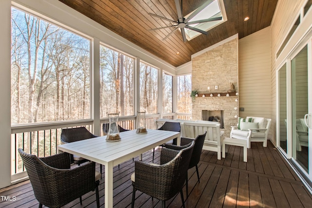 7212 Summer Tanager Trl, Raleigh, NC 27614 - sunroom / solarium featuring ceiling fan, a skylight, vaulted ceiling, outdoor dining area, and an outdoor living space with a fireplace