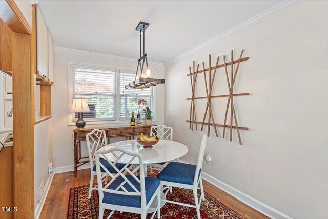 2913 Anderson Dr, Raleigh, NC 27608 - dining area featuring wood finished floors, ornamental molding, and baseboards