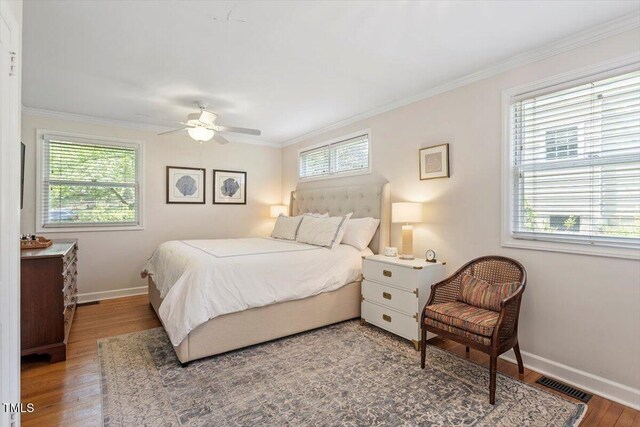 2913 Anderson Dr, Raleigh, NC 27608 - bedroom with multiple windows, wood finished floors, and crown molding