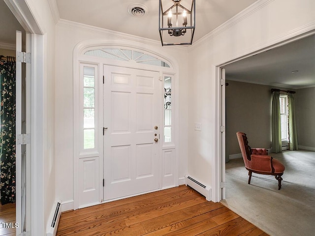 2228 Walker Ave, Burlington, NC 27215 - entryway with a baseboard radiator, ornamental molding, wood finished floors, a chandelier, and baseboards