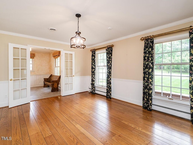 2228 Walker Ave, Burlington, NC 27215 - empty room featuring french doors, a baseboard heating unit, a wainscoted wall, light wood-type flooring, and a chandelier