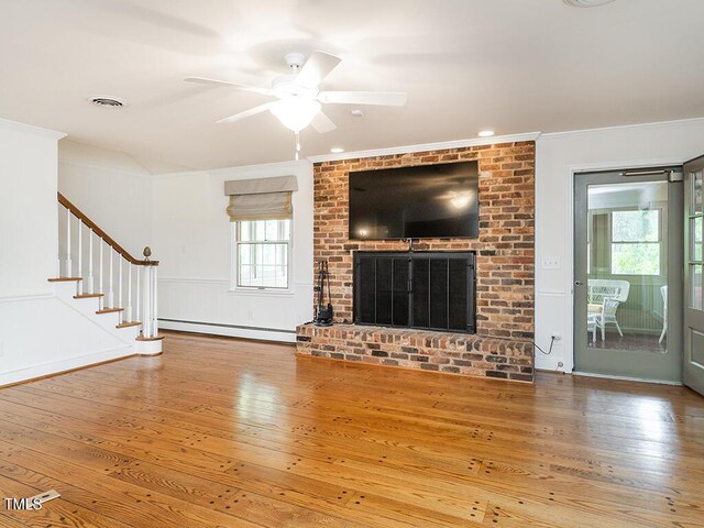 2228 Walker Ave, Burlington, NC 27215 - unfurnished living room featuring baseboard heating, hardwood / wood-style floors, crown molding, a ceiling fan, and stairs