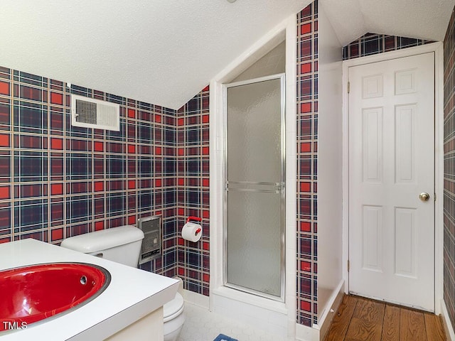 2228 Walker Ave, Burlington, NC 27215 - full bathroom featuring lofted ceiling, toilet, a stall shower, tile walls, and wood finished floors