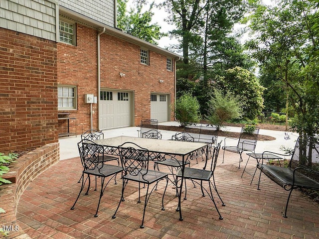 2228 Walker Ave, Burlington, NC 27215 - view of patio with an attached garage, outdoor dining area, and driveway