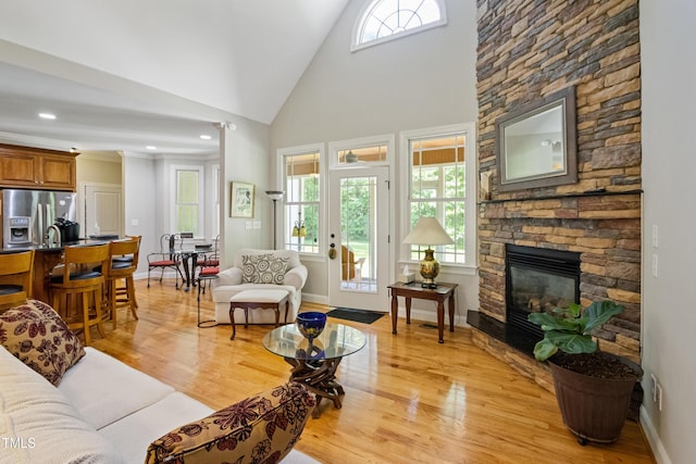 200 Daniel Ridge Ln, Roxboro, NC 27574 - living area with light wood-style flooring, a stone fireplace, and high vaulted ceiling