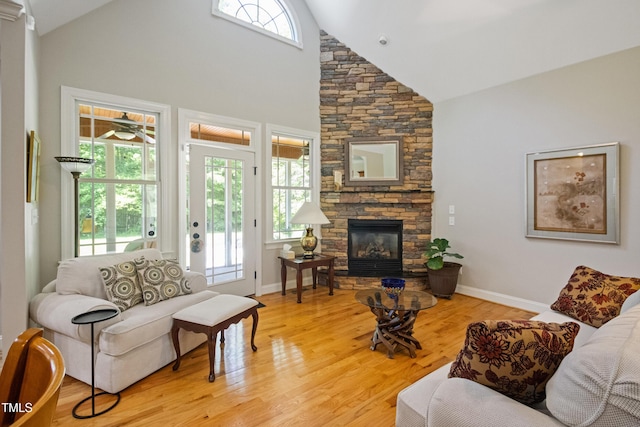 200 Daniel Ridge Ln, Roxboro, NC 27574 - living room with high vaulted ceiling, a stone fireplace, light wood finished floors, and baseboards