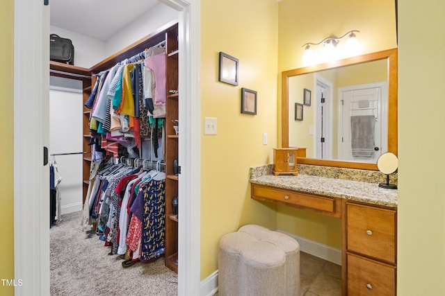 200 Daniel Ridge Ln, Roxboro, NC 27574 - bathroom with a walk in closet, vanity, and baseboards