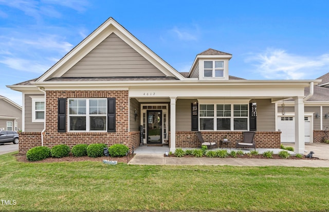 4612 Hanging Fern Ln, Raleigh, NC 27604 - view of front facade featuring brick siding, covered porch, a front yard, and an attached garage