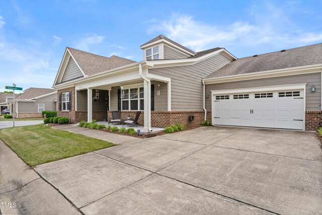 4612 Hanging Fern Ln, Raleigh, NC 27604 - view of front of property with brick siding, covered porch, driveway, a garage, and roof with shingles