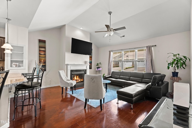 4612 Hanging Fern Ln, Raleigh, NC 27604 - living area featuring lofted ceiling, a glass covered fireplace, dark wood-type flooring, a ceiling fan, and baseboards