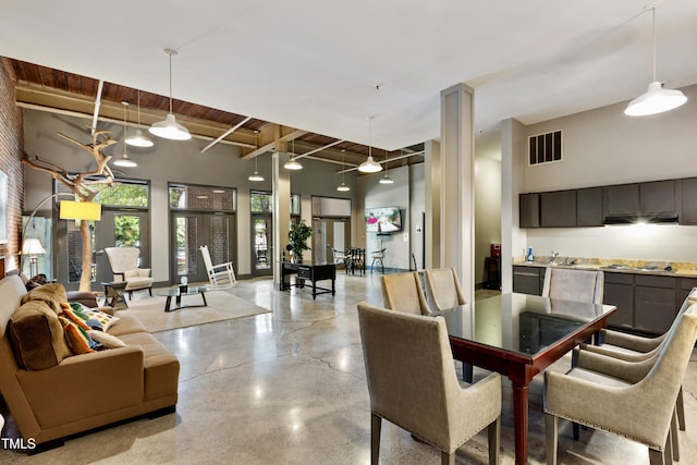 dining space featuring beamed ceiling, finished concrete flooring, and wood ceiling