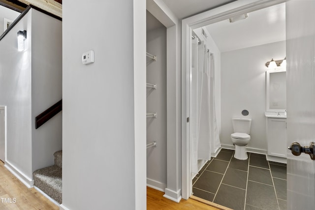 bathroom featuring toilet, baseboards, a shower with curtain, and tile patterned floors