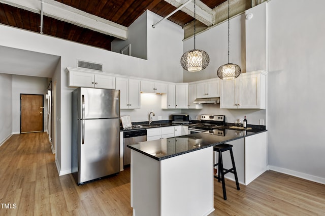 kitchen featuring appliances with stainless steel finishes, under cabinet range hood, wooden ceiling, high vaulted ceiling, and beam ceiling