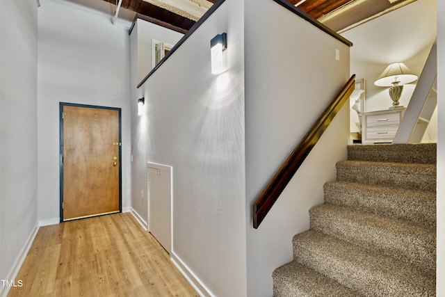 stairs with wood finished floors and baseboards