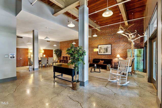 community lobby with brick wall, beam ceiling, wooden ceiling, and a high ceiling