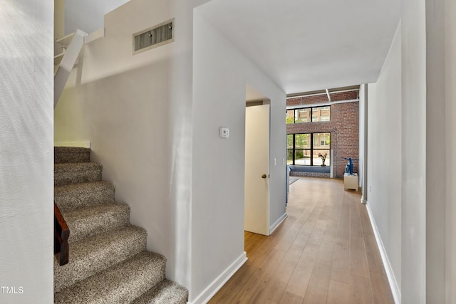 staircase featuring wood finished floors and baseboards