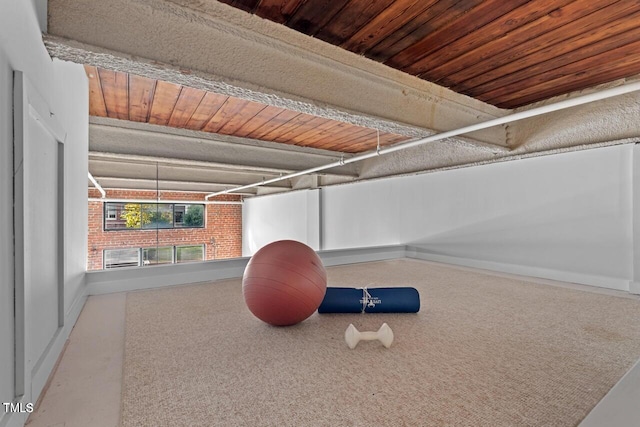 exercise room with baseboards, wooden ceiling, and carpet