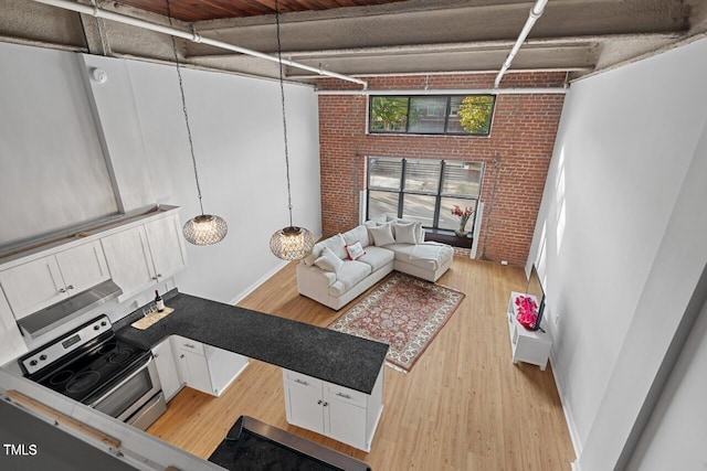 living room featuring brick wall and light wood-type flooring
