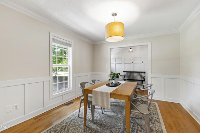 5413 Lower Creek Ct, Apex, NC 27539 - dining space featuring wood finished floors, ornamental molding, a wainscoted wall, and a decorative wall