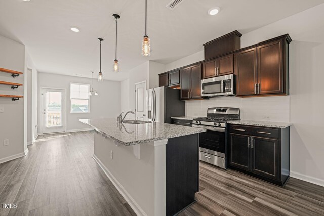 6618 Perry Creek Rd, Raleigh, NC 27616 - kitchen featuring appliances with stainless steel finishes, a sink, dark wood-style floors, tasteful backsplash, and an island with sink