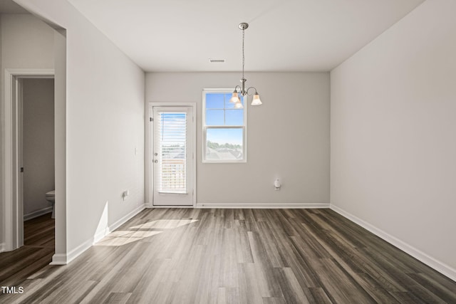6618 Perry Creek Rd, Raleigh, NC 27616 - unfurnished room featuring dark wood-type flooring, a chandelier, and baseboards