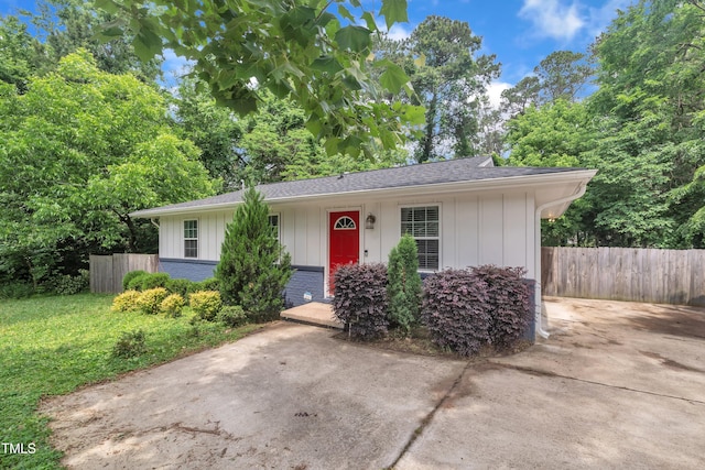view of front of house featuring board and batten siding, brick siding, and a shingled roof