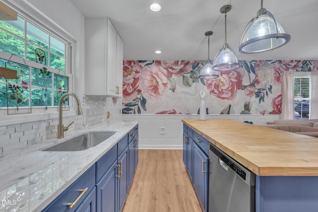 kitchen with blue cabinets, dishwasher, butcher block counters, a sink, and light wood-style floors