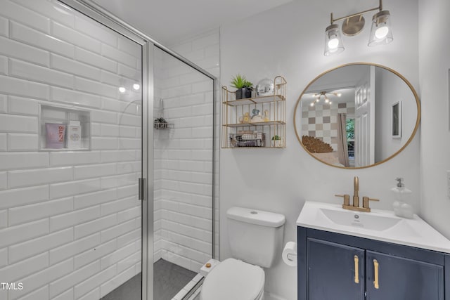 bathroom with a shower stall, toilet, and vanity