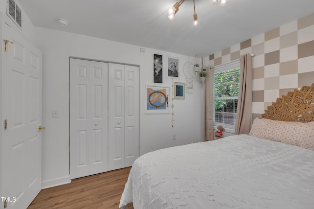 bedroom featuring wood finished floors, a closet, and baseboards