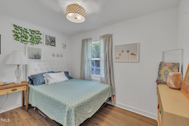 bedroom featuring wood finished floors and baseboards