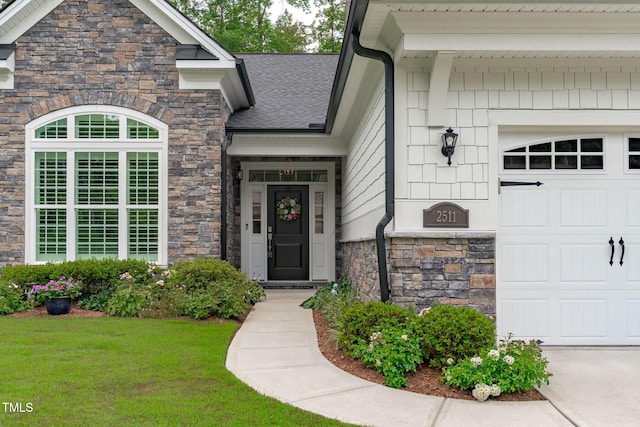 2511 Range Overlook Xing, Apex, NC 27523 - property entrance featuring stone siding, an attached garage, a yard, and roof with shingles