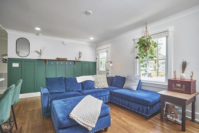 living area with ornamental molding and wood finished floors
