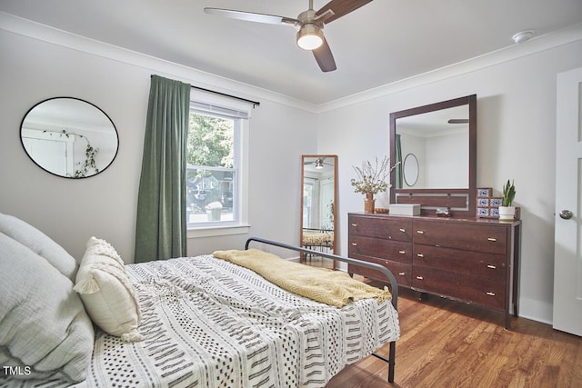 bedroom with wood finished floors, crown molding, and ceiling fan