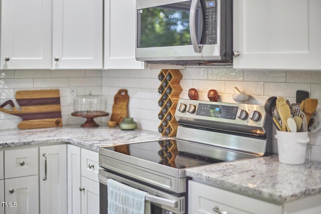 kitchen featuring appliances with stainless steel finishes, white cabinetry, and tasteful backsplash