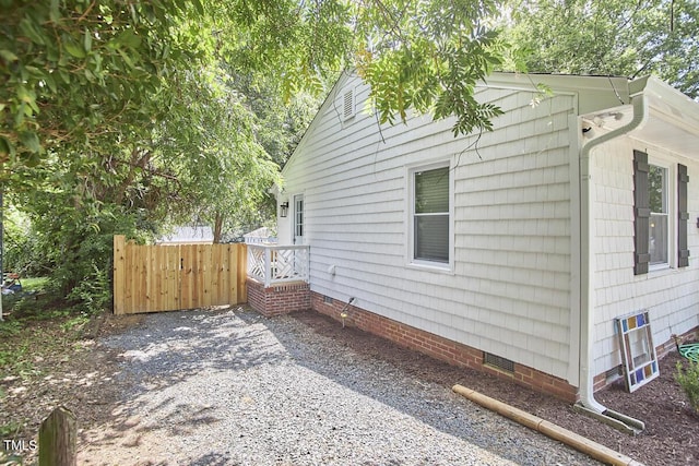 view of home's exterior featuring crawl space and fence